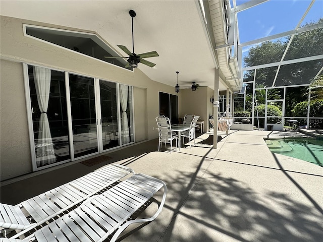 view of patio with ceiling fan and glass enclosure