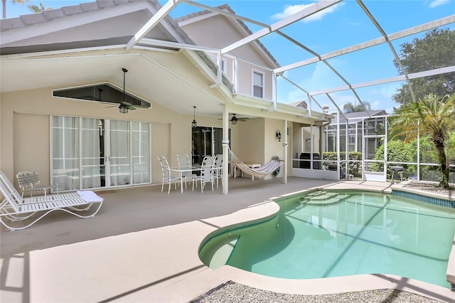 view of pool with ceiling fan, glass enclosure, and a patio