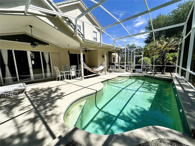 view of pool featuring ceiling fan, a patio area, and a lanai