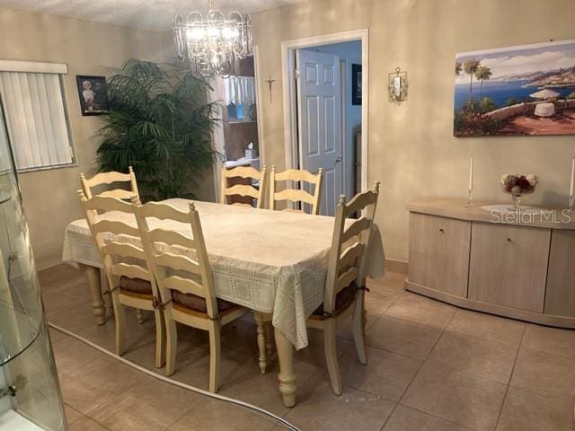 tiled dining space with a chandelier