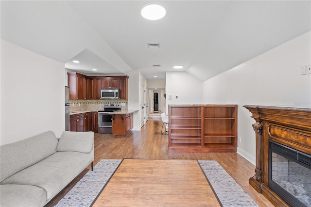 living room with lofted ceiling and light wood-type flooring