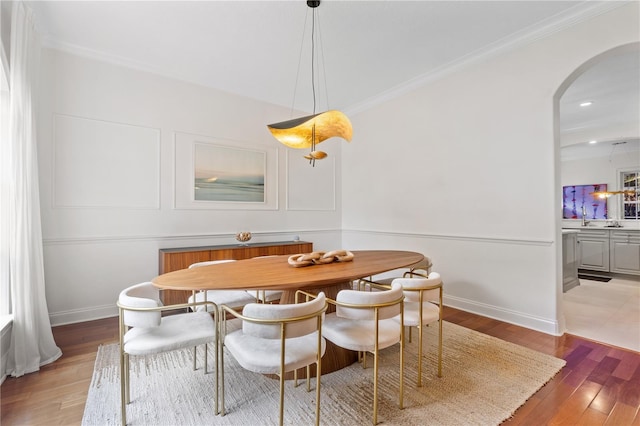 dining room featuring light hardwood / wood-style flooring and crown molding