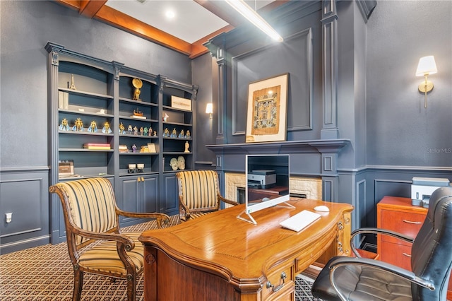 office area with carpet floors, built in shelves, and beamed ceiling