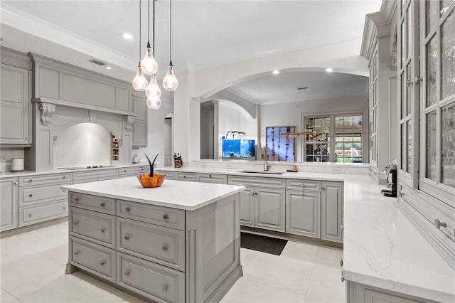 kitchen with black electric stovetop, a center island, kitchen peninsula, sink, and gray cabinetry