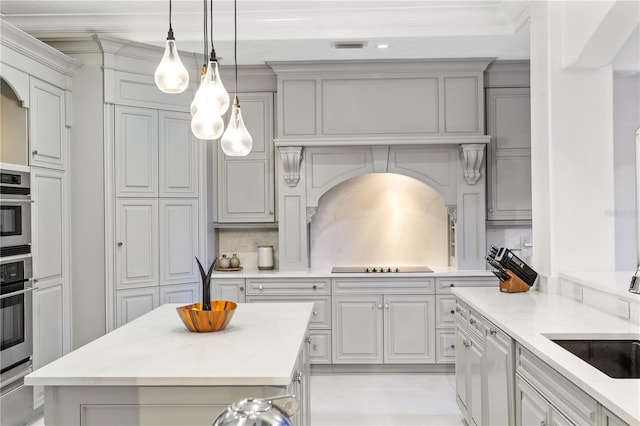 kitchen with decorative light fixtures, backsplash, black electric stovetop, gray cabinets, and light stone countertops