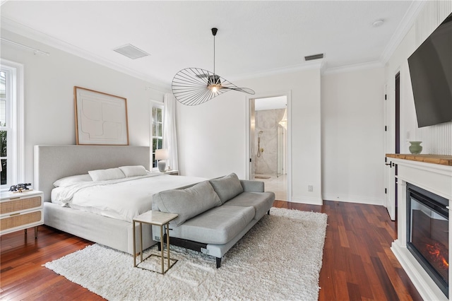 bedroom featuring ceiling fan, dark wood-type flooring, ensuite bathroom, and crown molding