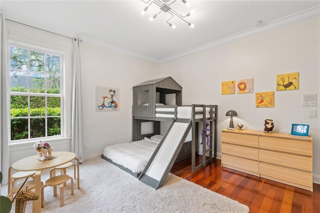 bedroom featuring a textured ceiling, dark wood-type flooring, and crown molding