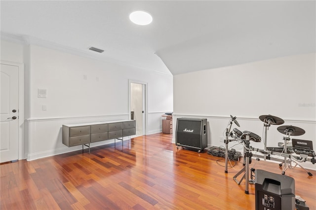 workout area featuring vaulted ceiling and hardwood / wood-style floors