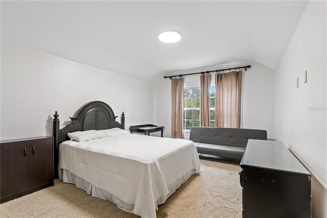 bedroom with vaulted ceiling and light carpet