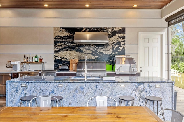 kitchen with stone counters, wooden ceiling, and wooden walls