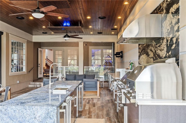 view of patio with ceiling fan, grilling area, an outdoor wet bar, and area for grilling