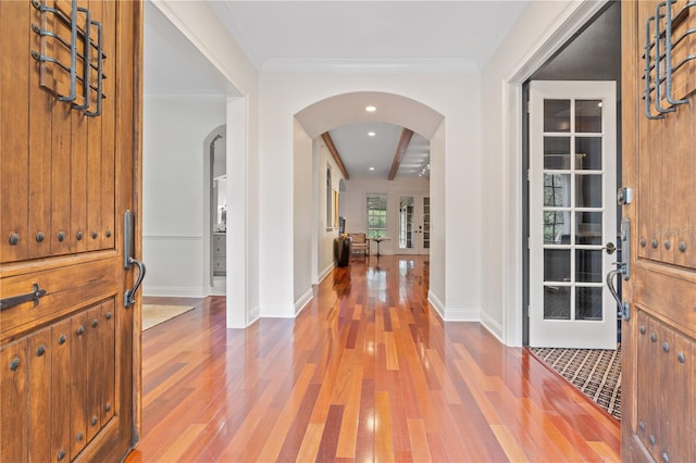 entrance foyer with french doors, beamed ceiling, ornamental molding, and hardwood / wood-style flooring