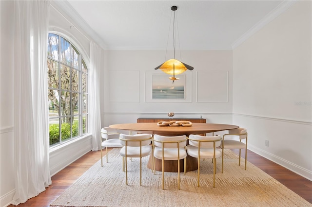 dining area featuring wood-type flooring and crown molding