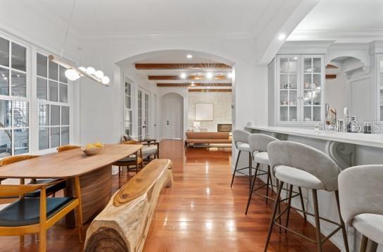 dining room with light hardwood / wood-style floors, beam ceiling, and crown molding