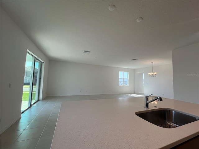 kitchen featuring light tile patterned floors, pendant lighting, a chandelier, and sink