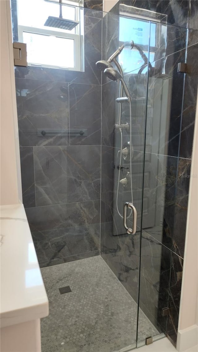 bathroom featuring a shower with shower door