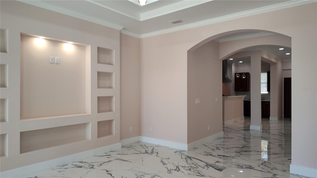 empty room with built in shelves and ornamental molding