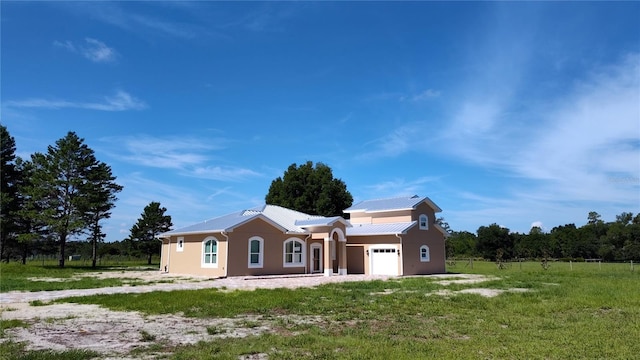 rear view of property with a garage and a yard