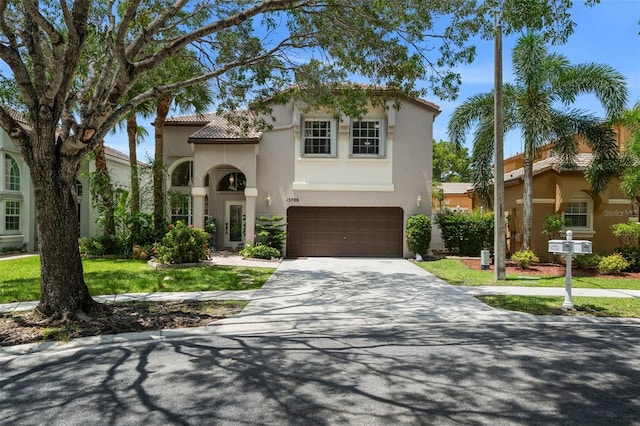 mediterranean / spanish house featuring a tiled roof, stucco siding, driveway, and a garage