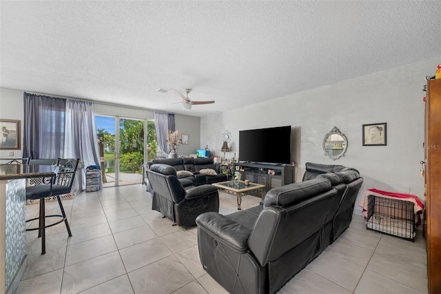 living area with light tile patterned floors, a textured ceiling, and a ceiling fan