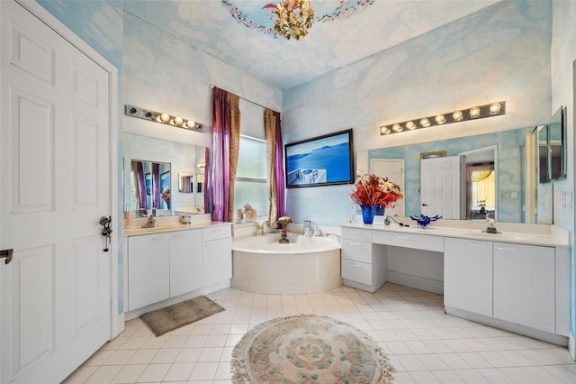 bathroom featuring tile patterned floors, two vanities, a bath, and a sink