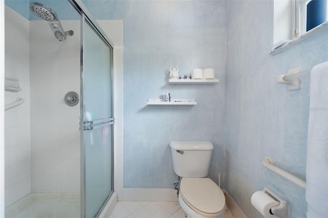 bathroom with tile patterned floors, toilet, and a stall shower