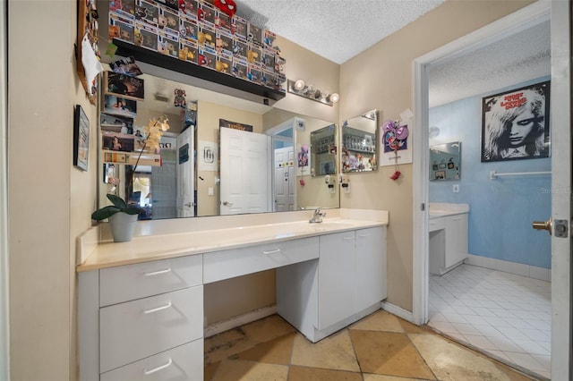 bathroom featuring vanity, baseboards, and a textured ceiling