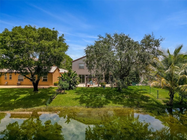 exterior space with a water view, a lawn, and fence