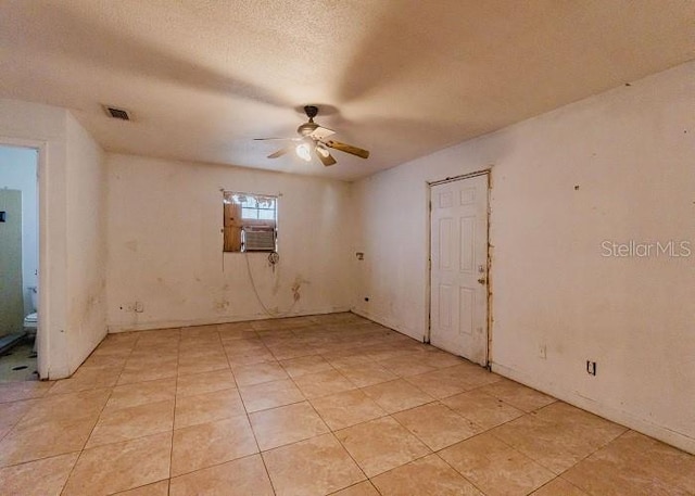 empty room with a textured ceiling and ceiling fan