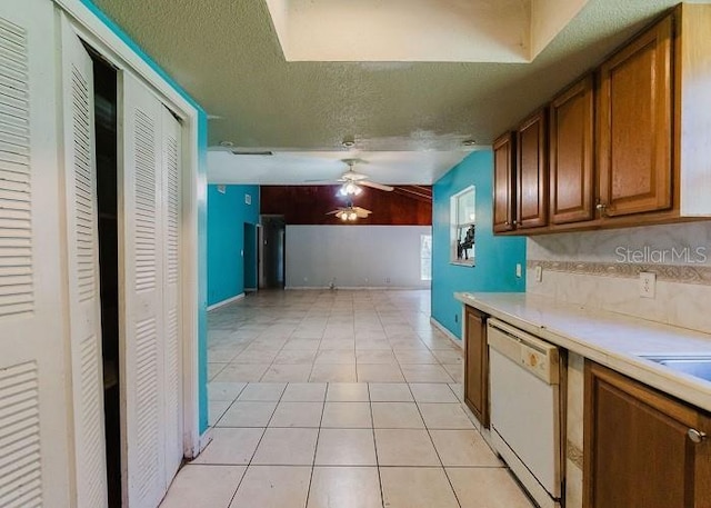 kitchen featuring ceiling fan, dishwasher, a textured ceiling, lofted ceiling, and light tile patterned floors