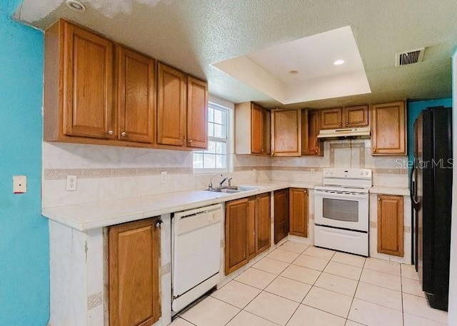 kitchen featuring sink, a raised ceiling, a textured ceiling, white appliances, and light tile patterned floors