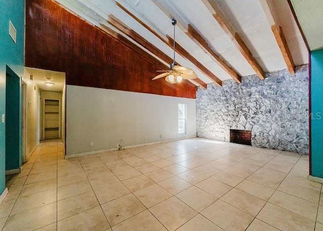 unfurnished living room featuring high vaulted ceiling, a stone fireplace, ceiling fan, beamed ceiling, and light tile patterned flooring