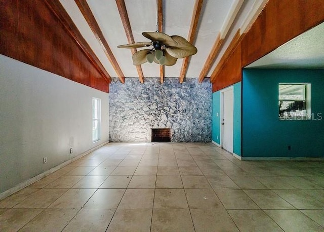 unfurnished living room featuring lofted ceiling with beams, light tile patterned flooring, and ceiling fan