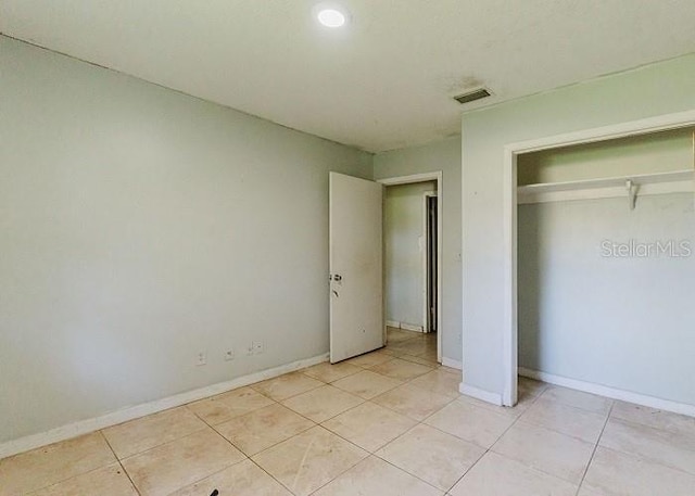 unfurnished bedroom featuring light tile patterned flooring and a closet