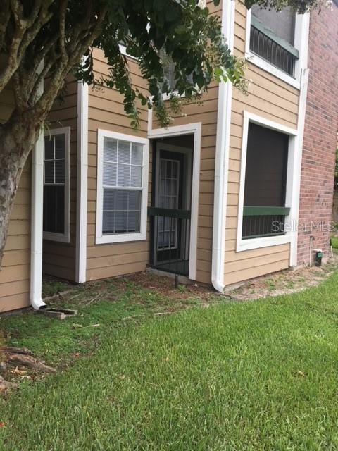 doorway to property with a yard