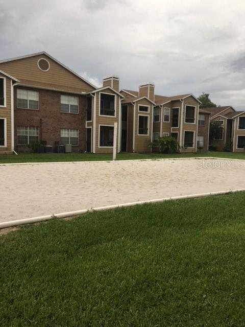 view of community featuring a lawn and volleyball court