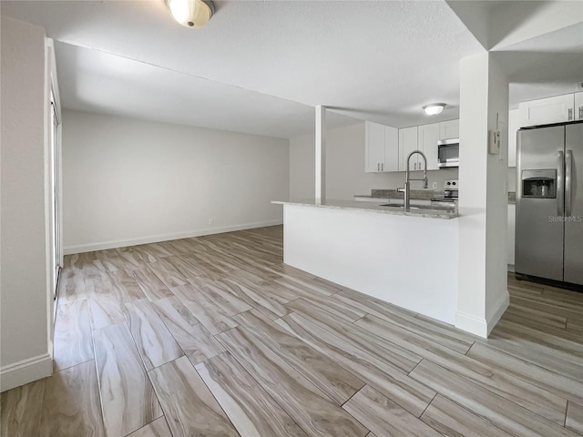 kitchen with white cabinets, appliances with stainless steel finishes, and kitchen peninsula