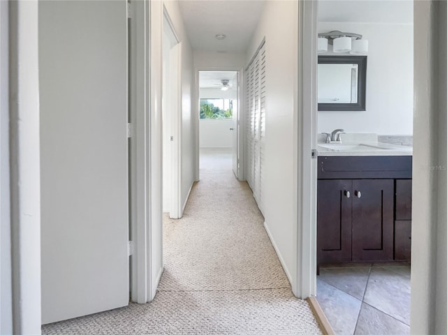 hall with sink and light colored carpet