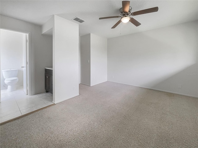 spare room featuring ceiling fan and light carpet