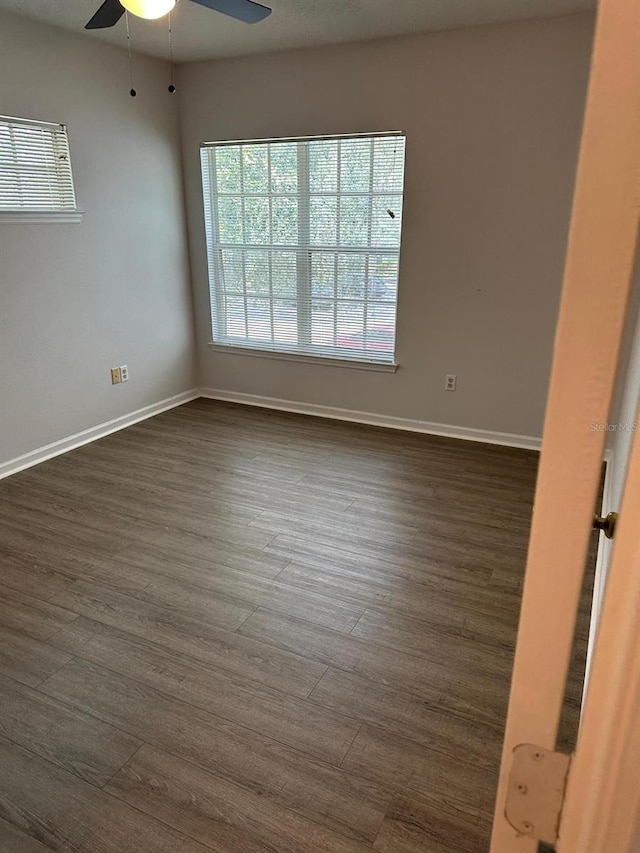 empty room featuring dark hardwood / wood-style flooring and ceiling fan