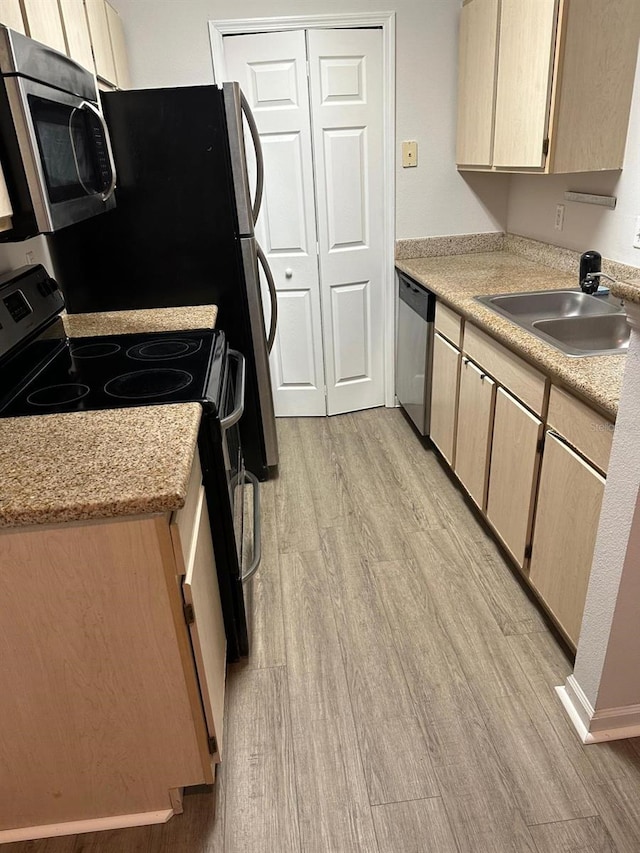 kitchen with light brown cabinetry, sink, light hardwood / wood-style flooring, and stainless steel appliances