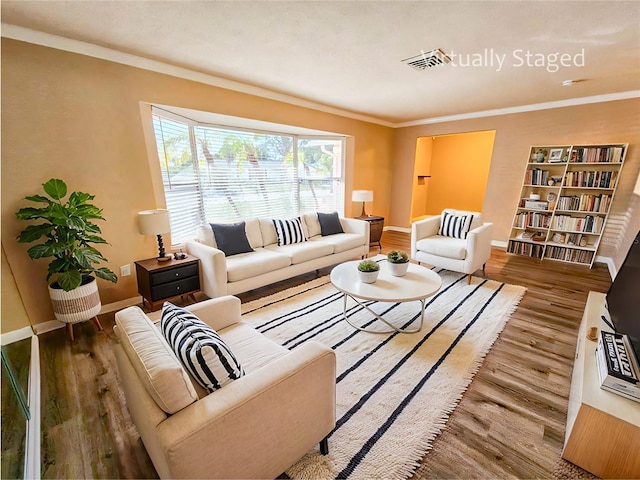 living room featuring hardwood / wood-style floors and crown molding