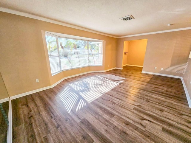 spare room featuring wood-type flooring and ornamental molding