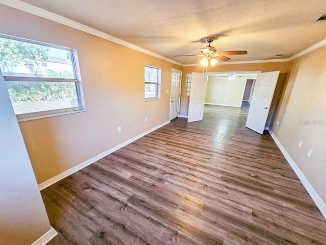 interior space with wood-type flooring, ornamental molding, and a healthy amount of sunlight