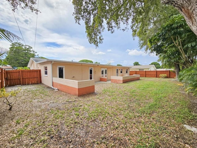 rear view of house featuring a yard