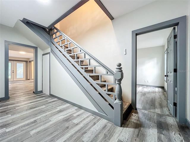 staircase with hardwood / wood-style floors and french doors