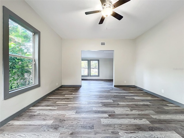 empty room with dark wood-type flooring and ceiling fan