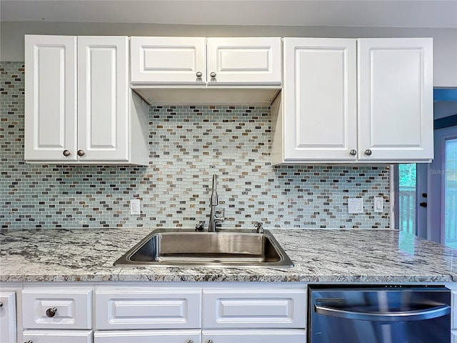 kitchen with white cabinets, tasteful backsplash, sink, and stainless steel dishwasher