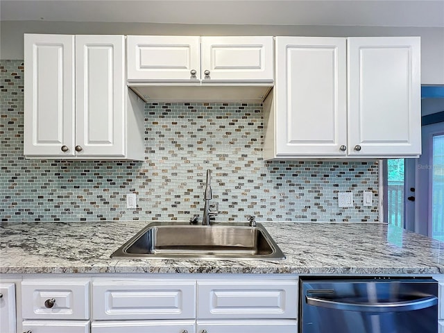 kitchen with tasteful backsplash, dishwasher, sink, and white cabinets