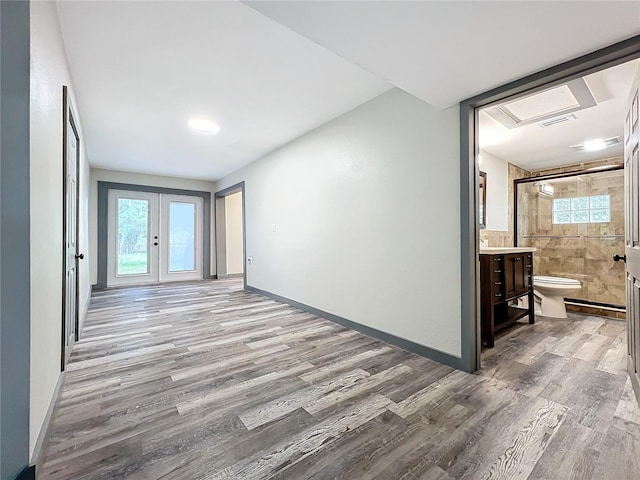 interior space with tile walls, french doors, and hardwood / wood-style floors